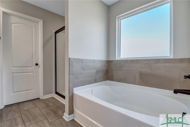 full bath featuring a stall shower, tile patterned flooring, and a garden tub