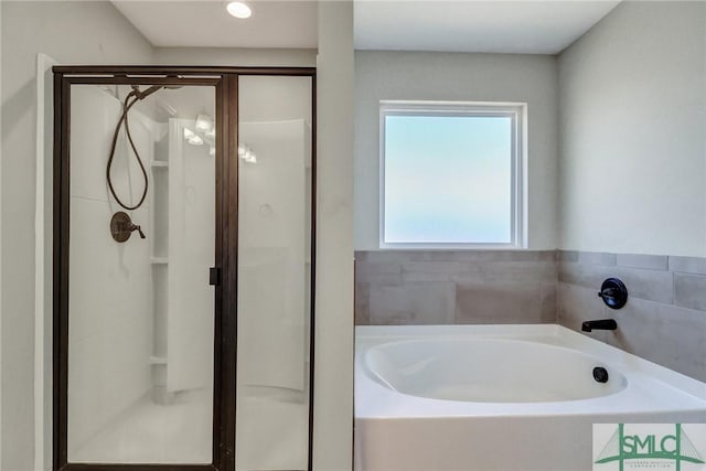 bathroom featuring a stall shower and a garden tub