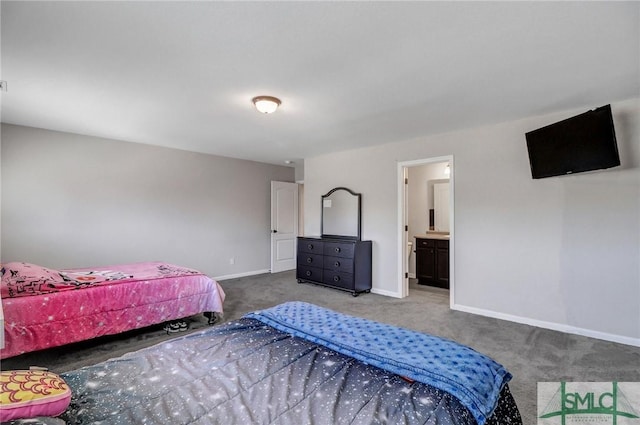 carpeted bedroom featuring ensuite bath and baseboards