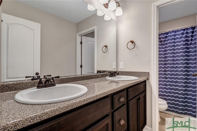 bathroom featuring toilet, a shower with curtain, double vanity, and a sink