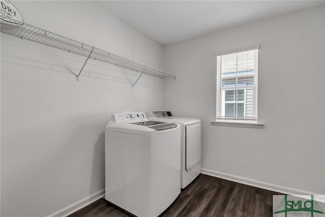 laundry area with laundry area, dark wood-type flooring, washing machine and dryer, and baseboards