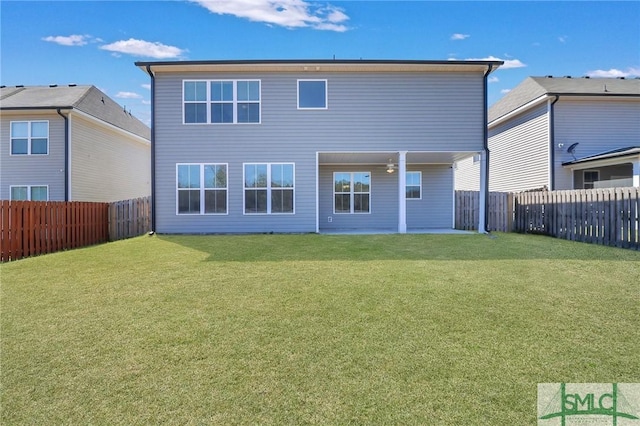 rear view of property with a fenced backyard and a yard