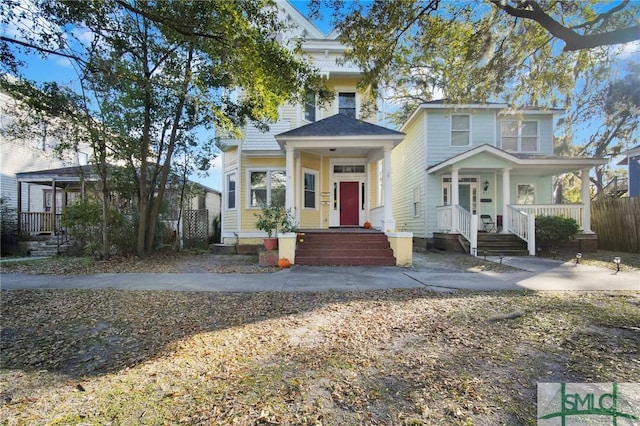 view of front of property with a porch and fence