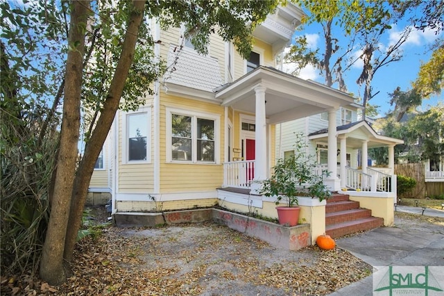 view of front of property featuring covered porch and fence