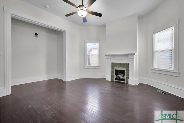 unfurnished living room with visible vents, a fireplace, baseboards, and wood finished floors