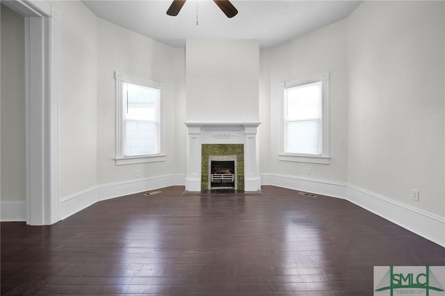 unfurnished living room with a fireplace with flush hearth, visible vents, a ceiling fan, baseboards, and wood-type flooring