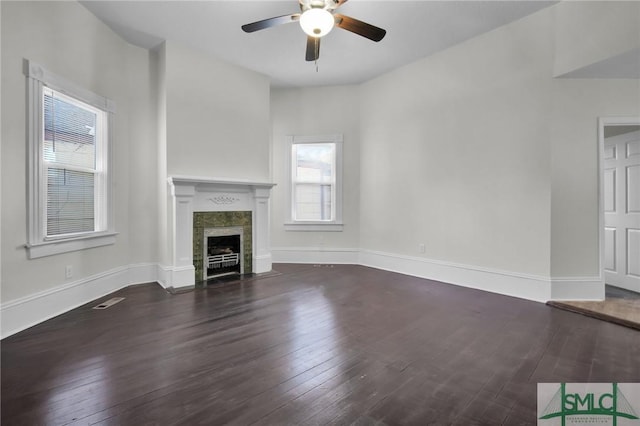 unfurnished living room featuring wood-type flooring, visible vents, baseboards, and a fireplace with flush hearth