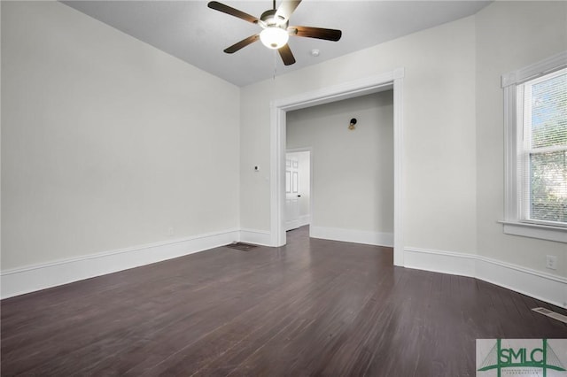 spare room with a ceiling fan, visible vents, baseboards, and wood finished floors