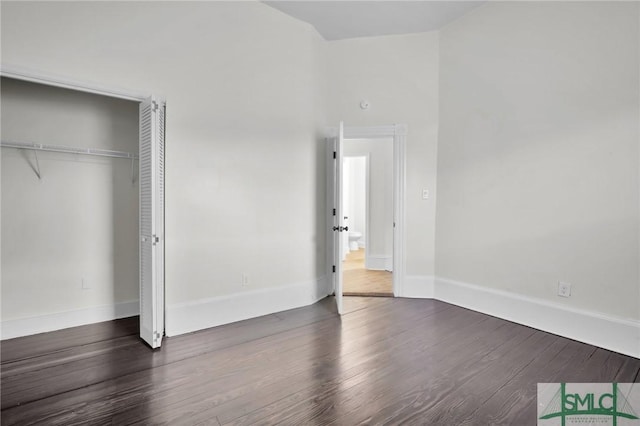 unfurnished bedroom featuring a closet, baseboards, and wood finished floors