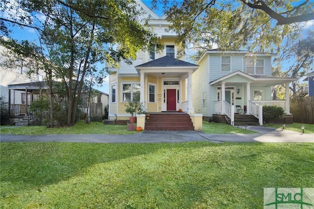 view of front of home with covered porch, a front lawn, and fence