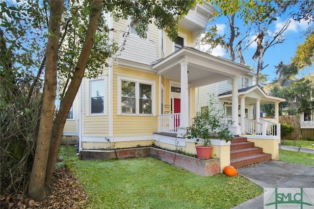 view of front facade featuring covered porch and a front yard