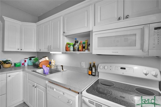 kitchen with light countertops, white appliances, a sink, and white cabinets