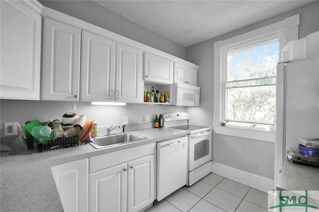 kitchen with light countertops, white cabinetry, a sink, a textured ceiling, and white appliances