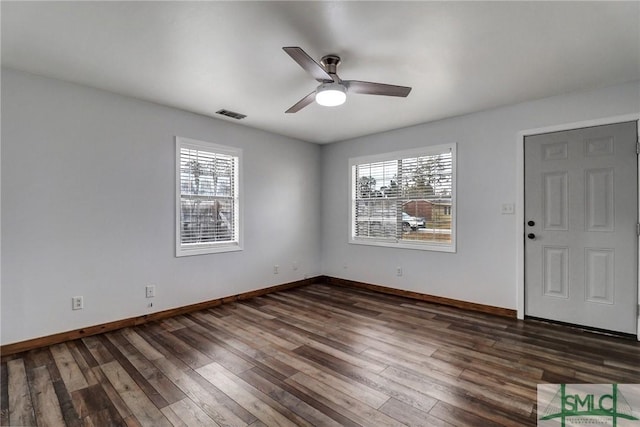 interior space with ceiling fan, dark wood-style flooring, visible vents, and baseboards