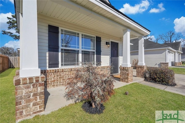 view of front of house with brick siding, a porch, fence, a garage, and a front lawn