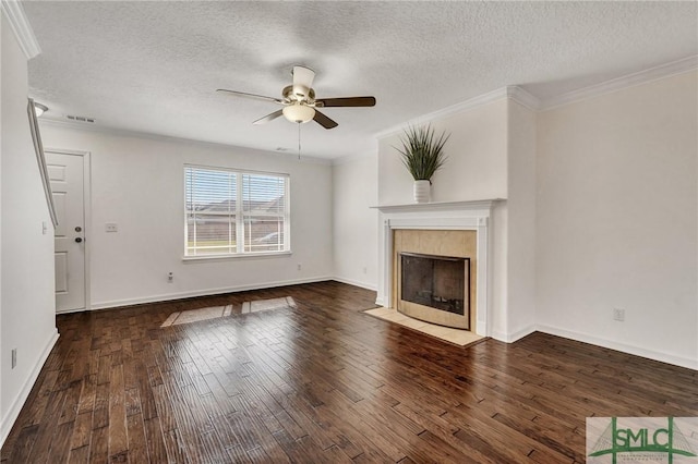 unfurnished living room featuring a ceiling fan, a tiled fireplace, visible vents, and wood finished floors