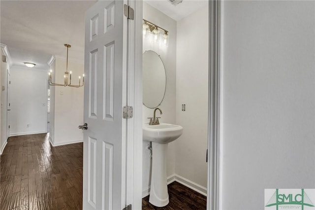 bathroom with ornamental molding, baseboards, and wood finished floors