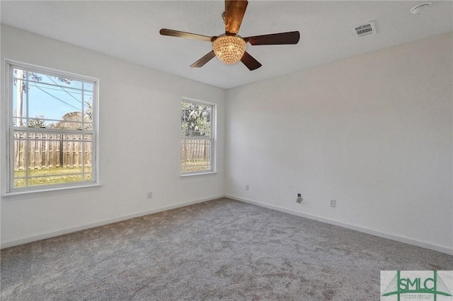 empty room featuring carpet, visible vents, ceiling fan, and baseboards