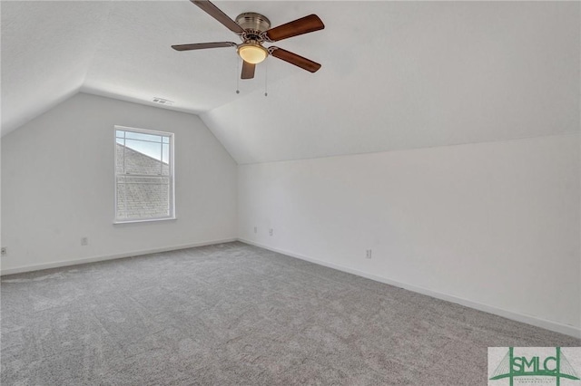 additional living space featuring carpet, lofted ceiling, visible vents, ceiling fan, and baseboards