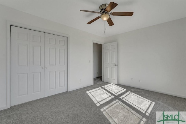 unfurnished bedroom featuring ceiling fan, a closet, and carpet flooring