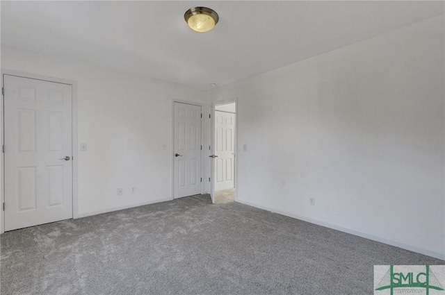 unfurnished bedroom with carpet flooring and baseboards