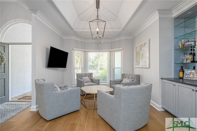 living room with light wood-style floors and a tray ceiling