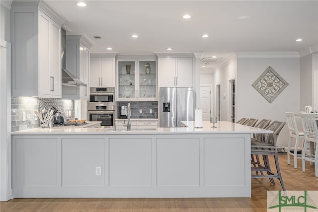 kitchen featuring appliances with stainless steel finishes, light countertops, a sink, a peninsula, and crown molding
