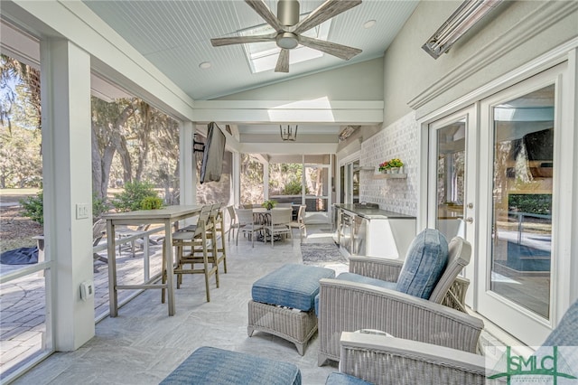 sunroom with outdoor dining space and a ceiling fan
