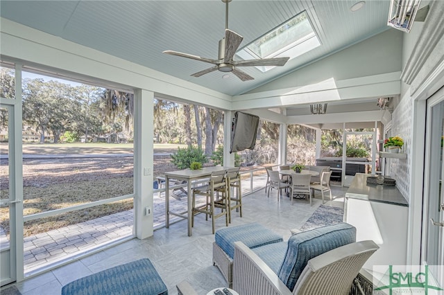 sunroom with a healthy amount of sunlight, outdoor dining area, and a ceiling fan