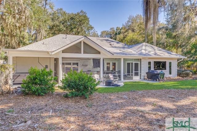 back of house with a shingled roof and a patio