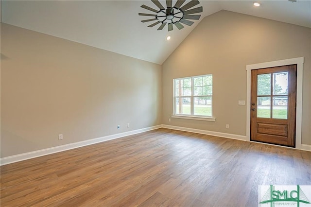 interior space featuring high vaulted ceiling, wood finished floors, a wealth of natural light, and baseboards