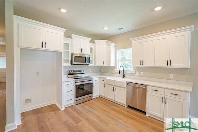 kitchen with recessed lighting, stainless steel appliances, a sink, visible vents, and light wood-style floors