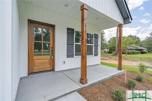 entrance to property with covered porch and board and batten siding