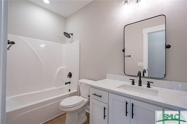 bathroom with washtub / shower combination, vanity, and toilet