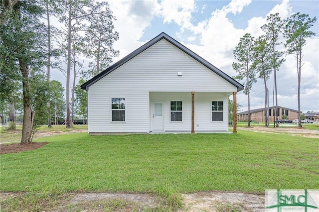 rear view of property featuring a lawn