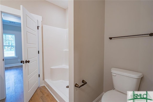 full bath with wood finished floors, baseboards, toilet, and a walk in shower