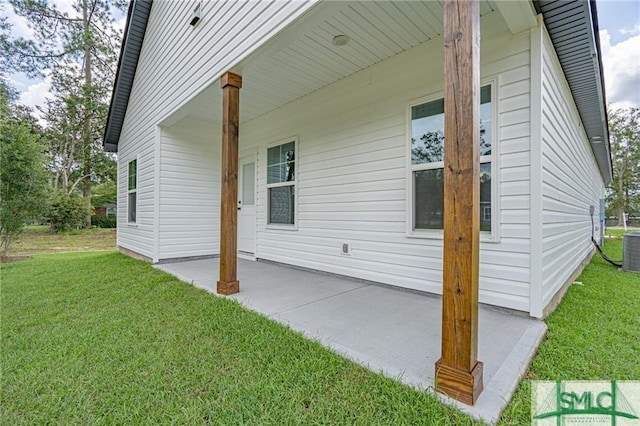 view of side of home with a patio area and a lawn