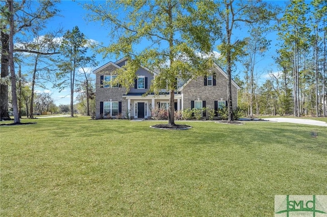 traditional-style home featuring brick siding and a front lawn