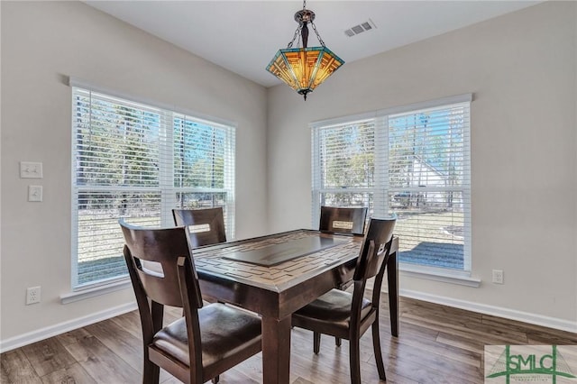 dining room featuring wood finished floors, visible vents, and baseboards