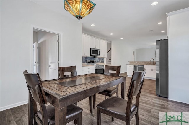 dining area featuring recessed lighting, baseboards, and wood finished floors