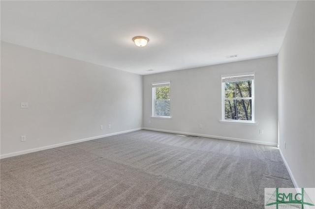 spare room with visible vents, carpet, and baseboards