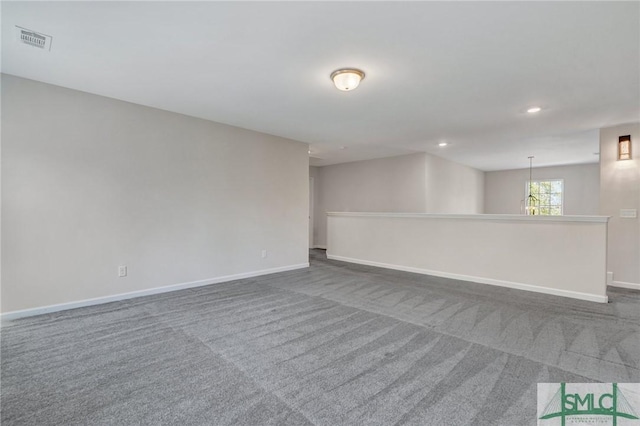 spare room with recessed lighting, visible vents, dark carpet, and baseboards