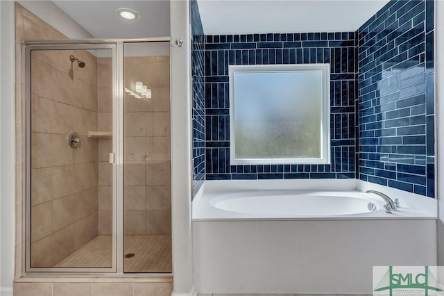 bathroom featuring a stall shower and a bath