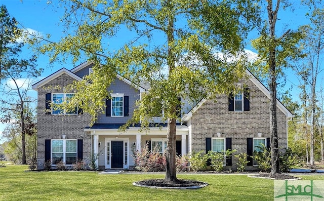 traditional-style house with brick siding and a front lawn