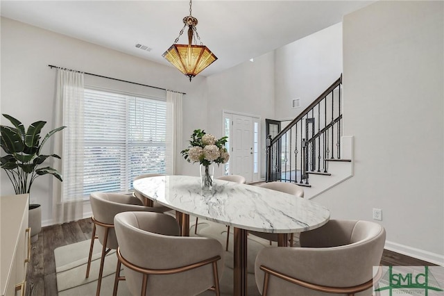 dining room featuring visible vents, baseboards, dark wood-type flooring, and stairway