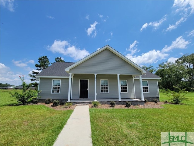 view of front of home featuring covered porch, a shingled roof, and a front yard