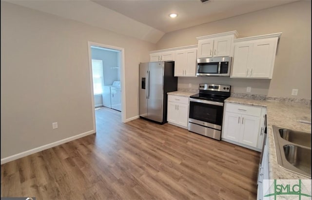 kitchen featuring separate washer and dryer, a sink, white cabinetry, appliances with stainless steel finishes, and light wood finished floors