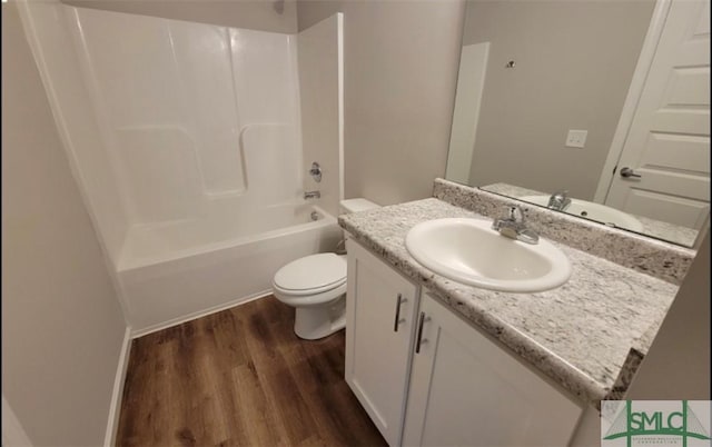 bathroom featuring toilet, bathing tub / shower combination, wood finished floors, and vanity