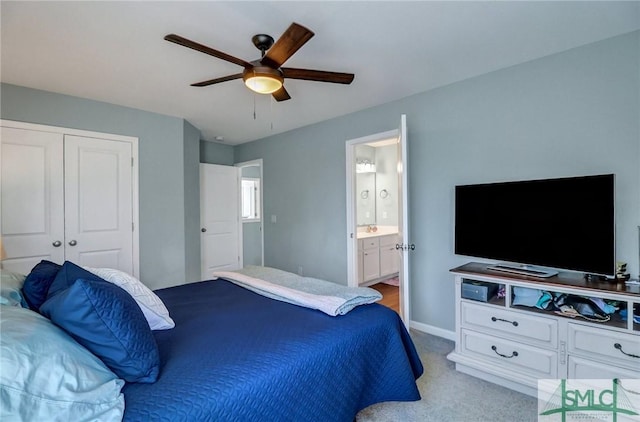 carpeted bedroom featuring ceiling fan, baseboards, a closet, and ensuite bathroom