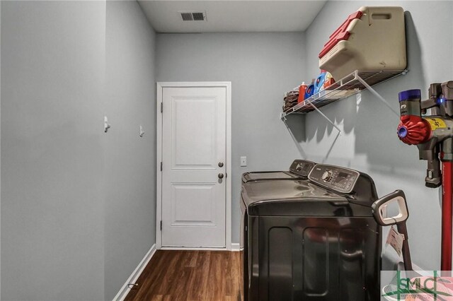 clothes washing area with laundry area, wood finished floors, visible vents, baseboards, and washer and dryer